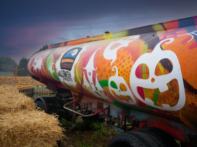 A painted halloween-themed tanker with hay bales in the foreground