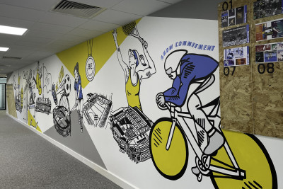 Office mural detail showing illustration of cyclist along with OSB pin board