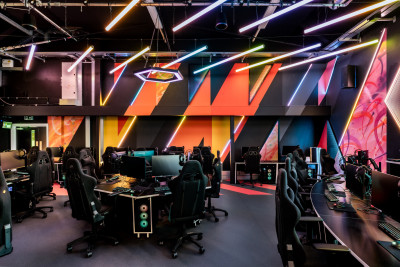 Orange feature walls with desks at the new E-Sports Arena at St Mary's University in Twickenham